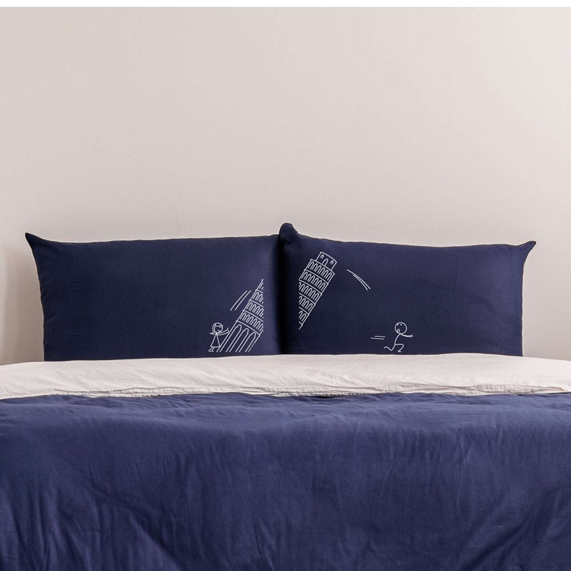 a bed with a blue comforter and pillows 
