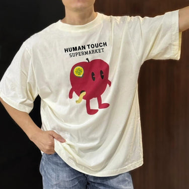 Human Touch apple graphic tee featuring a cartoon apple character in a relaxed fit for street fashion enthusiasts