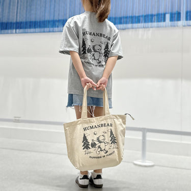 Eco-friendly canvas bag cute teddy bear printing held by a person in street fashion outfit