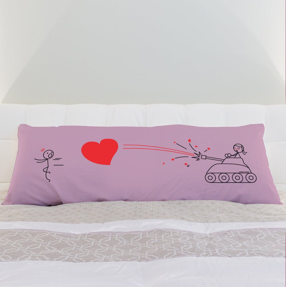 a pink pillow sitting on top of a bed 