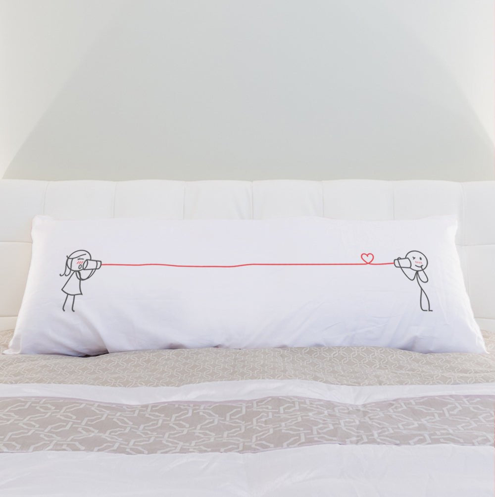 a bed with white sheets and pillows on it 