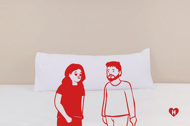 White long pillow with two red line-art characters on the front