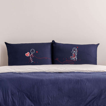 His and hers personalized anniversary gifts with cute stick figure designs on navy pillowcases