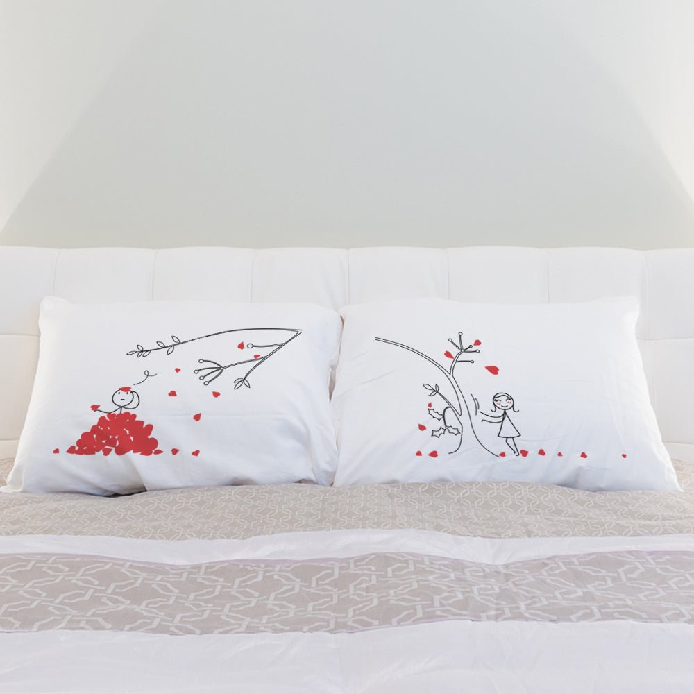 a bed with white sheets and red pillows 