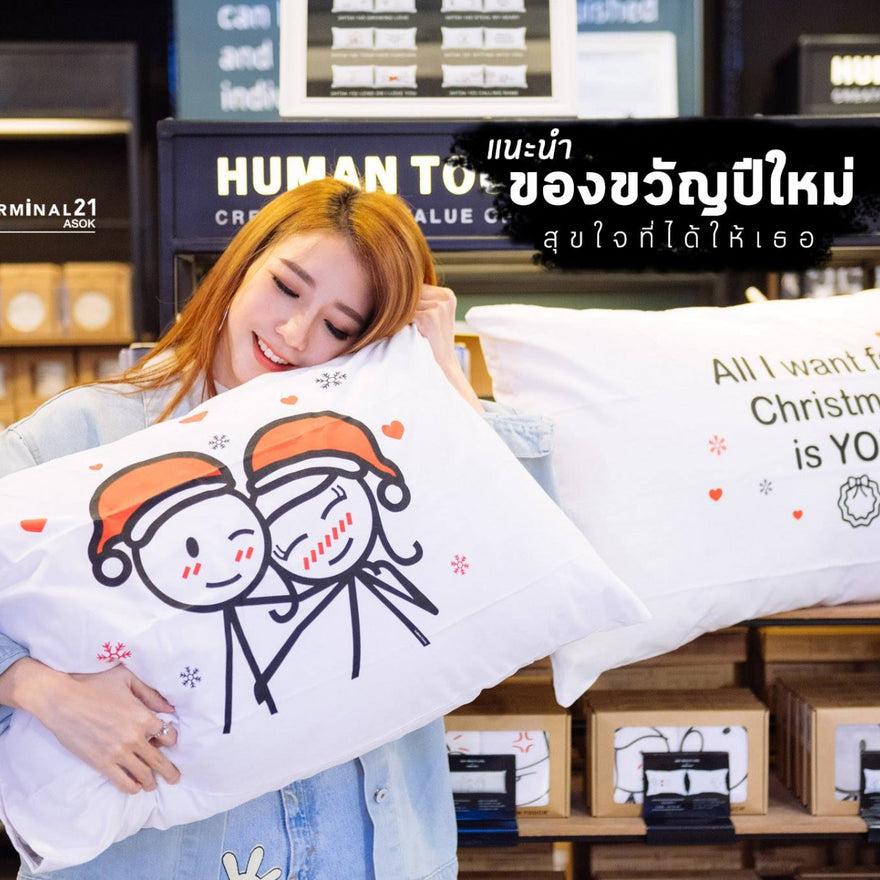 Couple with festive pillows featuring Christmas gift ideas for couples, perfect for a romantic surprise