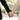 Couple holding hands outdoors, showcasing personalized wedding keepsakes in a romantic setting