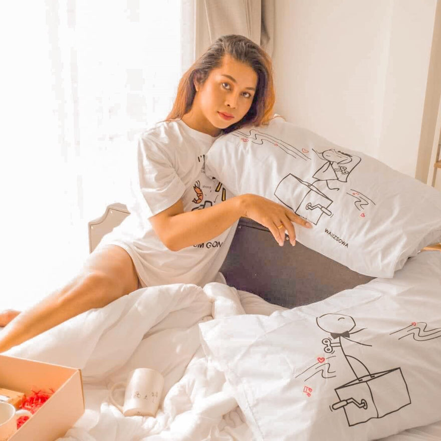 Cozy bedroom scene featuring a woman with decorative pillows, ideal for pre-Valentine's Day gift ideas.