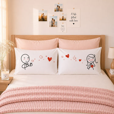 Two white pillowcases with red hearts and cartoon couple line art