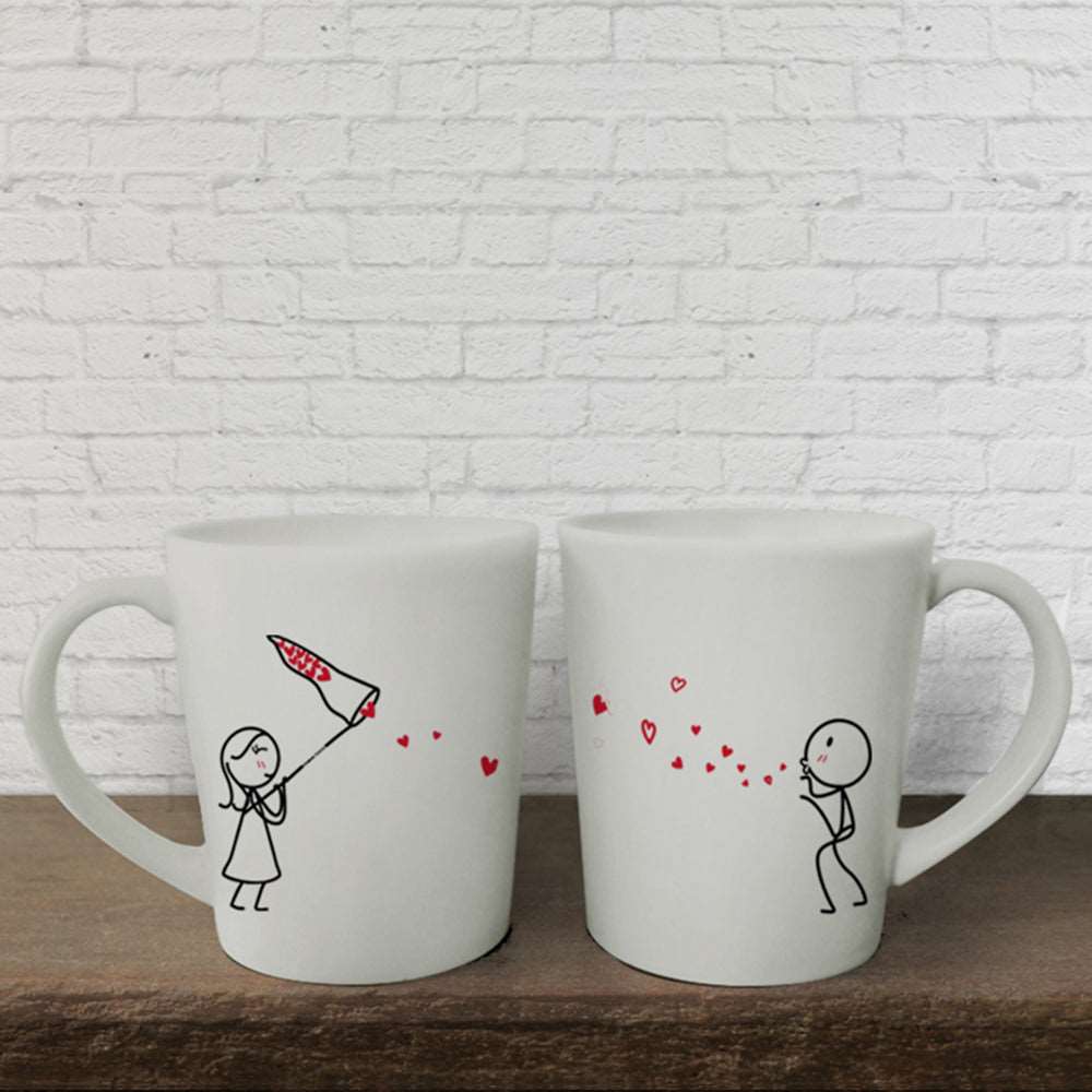 Transforming a simple idea into art, these charming white mugs feature delightful drawings – perfect for couples seeking a creative and cute anniversary gift.