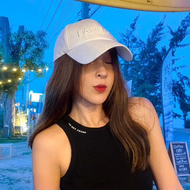 Black sleeveless tank top with small text and light baseball cap