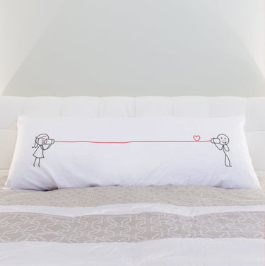 a bed with white sheets and pillows on it 