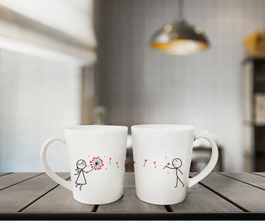 Cute anniversary gift for couples, white mugs featuring playful stick figures and flower designs, ideal for sharing morning coffee together