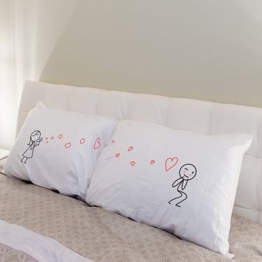 a white pillow sitting on top of a white bed 